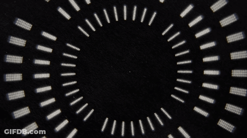 A Black Background With A Circular Pattern Of White Dots GIF