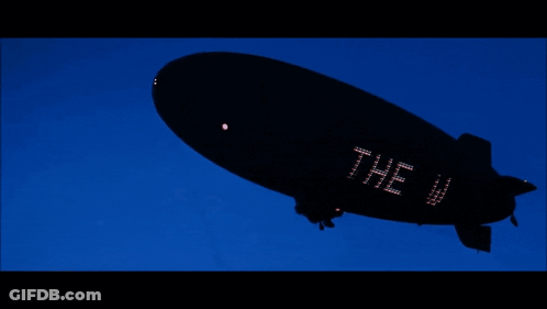 A Black Blimp With The Word The Wo On The Side GIF