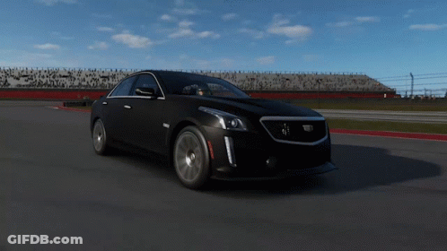 A Black Cadillac Is Driving Down A Track GIF