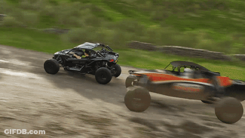 A Black Can-Am Buggy Is Driving Down A Dirt Road GIF