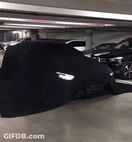 A Black Car Is Covered In A Black Cover GIF
