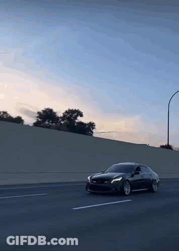 A Black Car Is Driving Down A Highway GIF