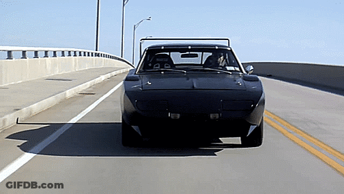 A Black Car Is Driving Down A Highway With A Yellow Line In The Middle GIF