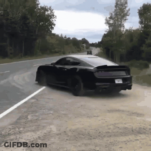A Black Car Is Driving Down A Road With A License Plate That Says ' A ' On It GIF