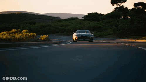 A Black Car Is Driving Down A Road With Trees In The Background GIF