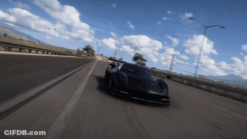 A Black Car Is Driving On A Highway With Mountains In The Background GIF