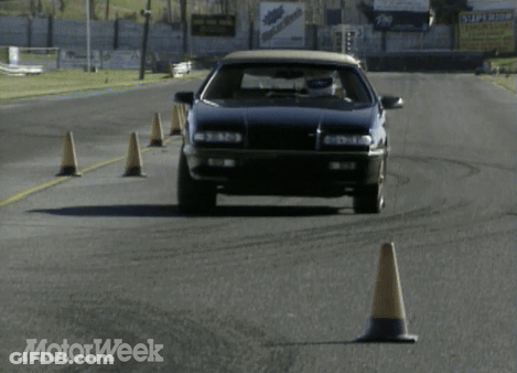 A Black Car Is Driving On A Road With A Motorweek Logo In The Corner GIF