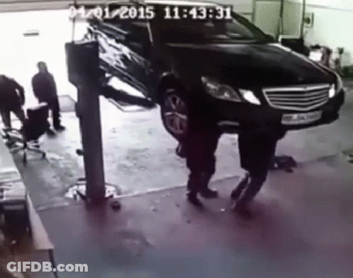 A Black Car Is On A Lift In A Garage With A Time Stamp Of 11:45:31 GIF