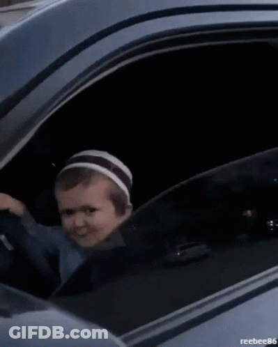 A Black Car Is Parked In Front Of A Building With A Reflection Of A Building In The Window . GIF