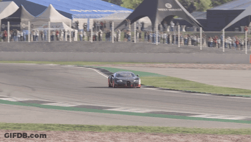 A Black Car With Red Wheels Is Driving On A Race Track GIF