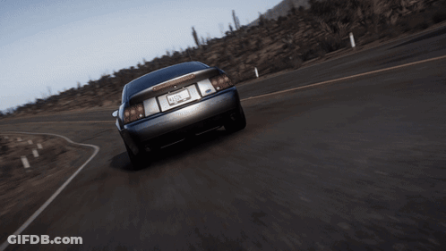 A Black Car With The Number 2 On The Side Is Driving Down The Road GIF