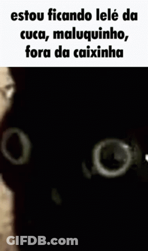 A Black Cat Is Looking At The Camera With A White Hand Behind It . GIF