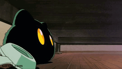 A Black Cat With Yellow Eyes Is Laying Under A Bed GIF