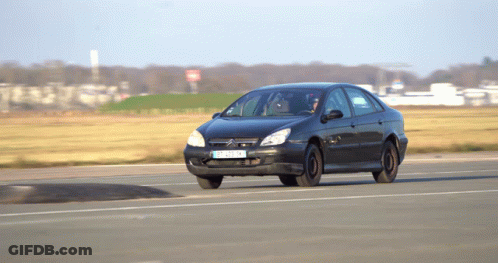 A Black Citroen Car With A License Plate That Says Tc - Nc - Nk Is Driving Down A Road GIF