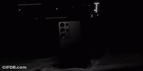 A Black Galaxy S21 Ultra Phone Is Sitting On A Table . GIF