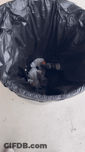 A Black Garbage Bag Filled With Bottles And Trash GIF