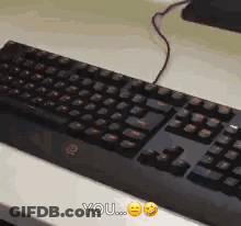 A Black Keyboard Is Sitting On A White Table And Says You On The Bottom GIF