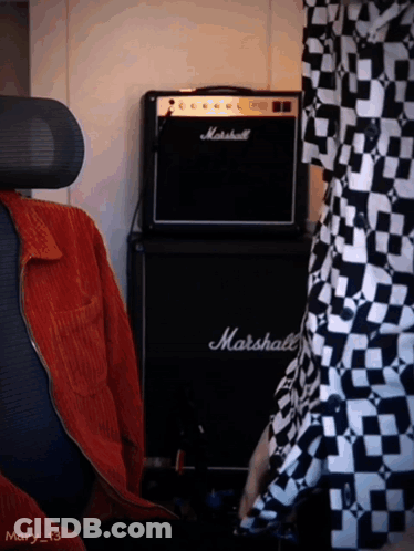 A Black Marshall Amplifier Sits In Front Of A Person GIF