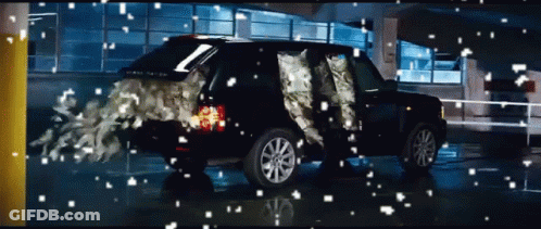 A Black Range Rover Is In A Parking Garage With Snow Falling On It GIF