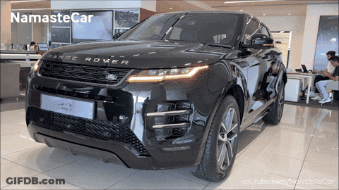 A Black Range Rover Sits In A Showroom GIF