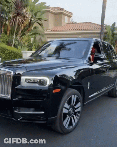 A Black Rolls Royce Is Parked On The Side Of The Road GIF