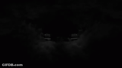A Black Rolls Royce Is Surrounded By Smoke In A Dark Room GIF