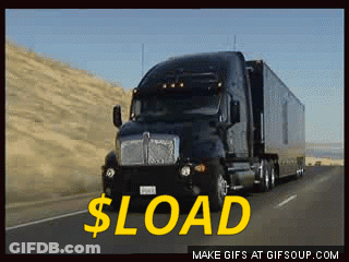 A Black Semi Truck Is Driving Down A Highway With The Words $ Load In Yellow GIF