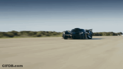 A Black Sports Car Is Driving Down A Track GIF