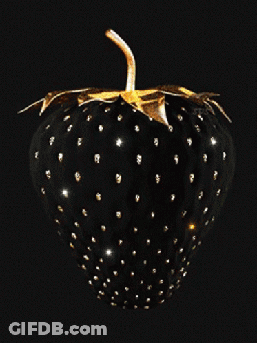 A Black Strawberry With Gold Spots And Leaves On A Black Background GIF