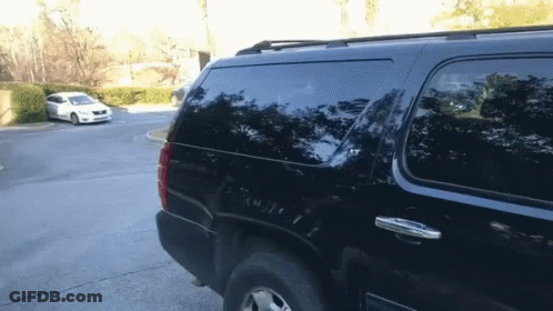 A Black Suv Is Parked In A Parking Lot With Other Cars GIF