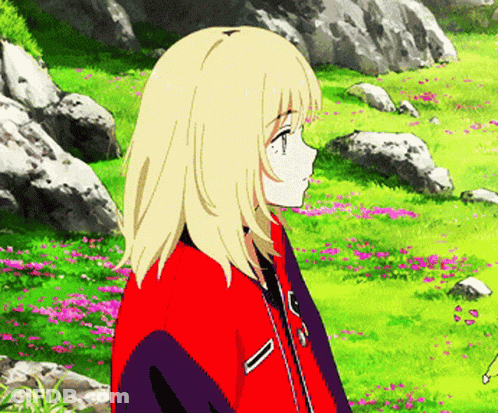 A Blonde Anime Girl In A Red Jacket Stands In A Field Of Flowers And Rocks GIF