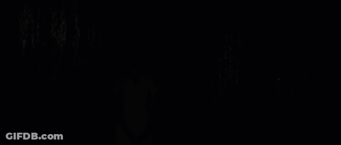 A Blonde Woman In A Pink Striped Shirt Looks At The Camera GIF