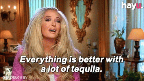 A Blonde Woman Is Sitting In A Living Room And Says Everything Is Better With A Lot Of Tequila . GIF