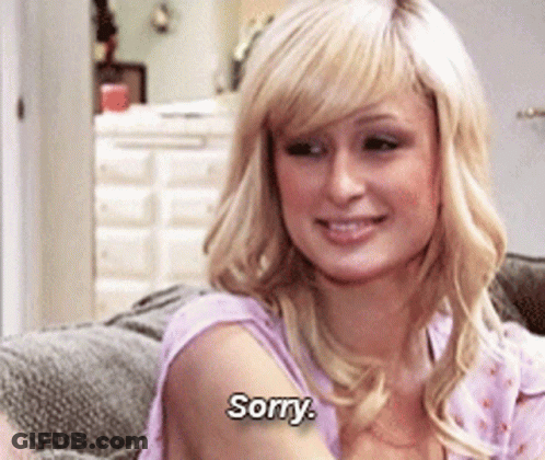 A Blonde Woman Is Sitting On A Couch And Saying Sorry GIF
