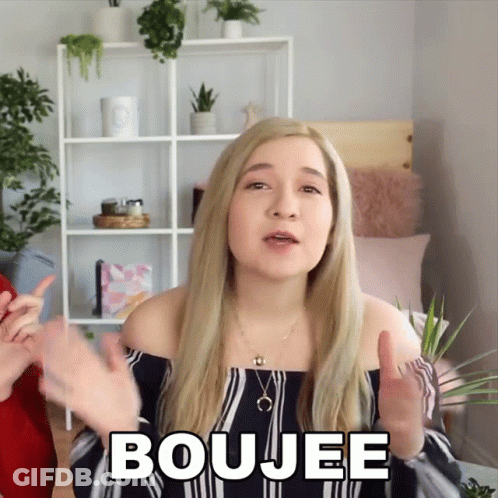 A Blonde Woman Says Boujee In Front Of A Shelf GIF