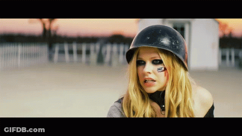A Blonde Woman Wearing A Black Helmet Has A Red Circle On Her Face GIF