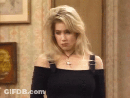 A Blonde Woman Wearing A Black Off The Shoulder Top And A Necklace GIF