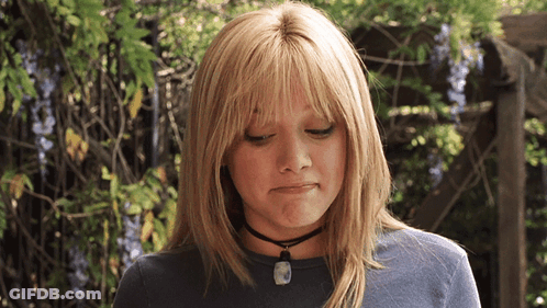 A Blonde Woman Wearing A Choker Necklace Looks Down GIF