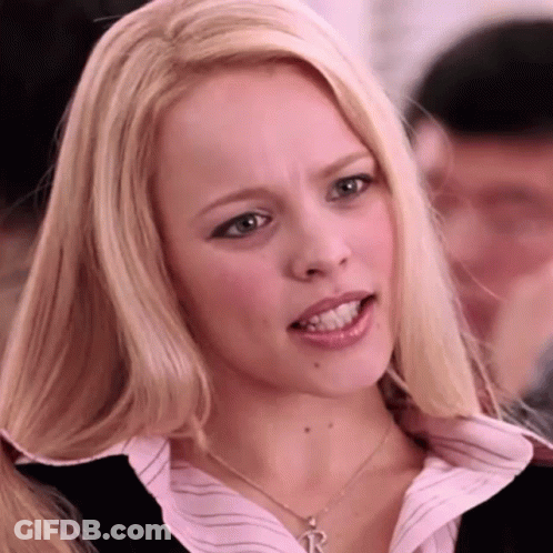A Blonde Woman Wearing A Necklace With A Letter R On It GIF