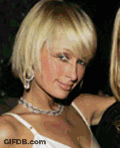 A Blonde Woman Wearing A White Tank Top And Necklace GIF