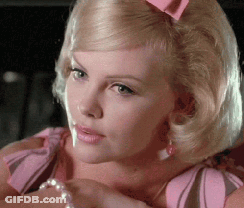 A Blonde Woman With A Pink Bow In Her Hair Is Wearing A Pearl Bracelet GIF