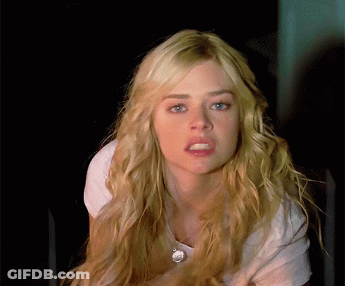 A Blonde Woman With Blue Eyes Is Wearing A White Shirt And Necklace GIF