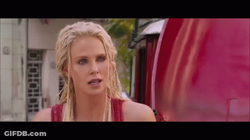 A Blonde Woman With Dreadlocks Is Standing In Front Of A Red Truck GIF