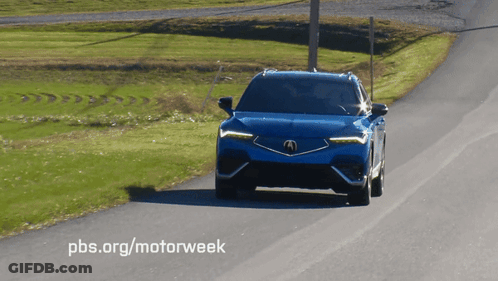 A Blue Acura Is Driving Down The Road GIF