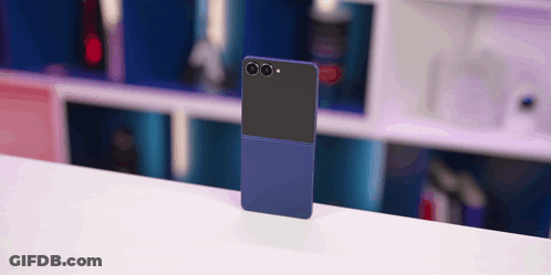 A Blue And Black Cell Phone Is Sitting On A White Table GIF