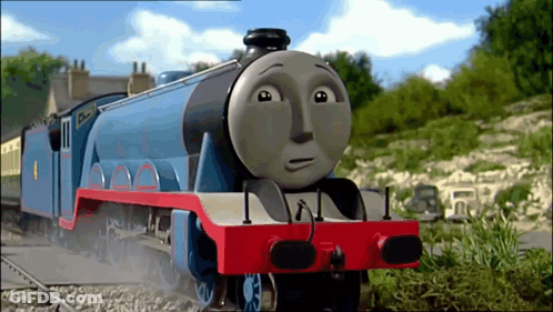 A Blue And Red Train With A Sad Face Is On The Tracks GIF