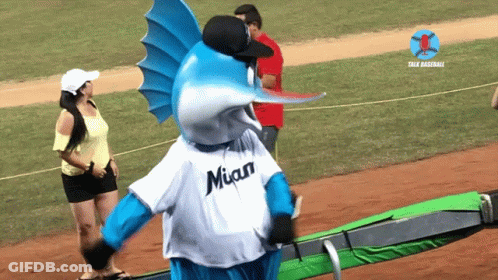 A Blue And White Fish Mascot Wearing A Miami Jersey GIF