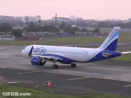 A Blue And White Indigo Airplane Is Taking Off From An Airport Runway GIF