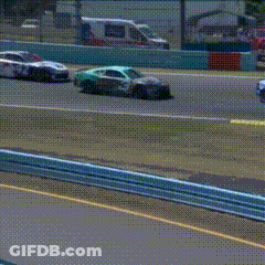 A Blue And White Race Car Is Driving Down A Track . GIF