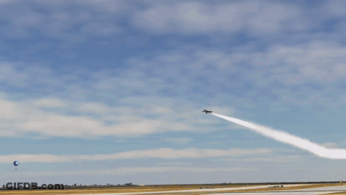 A Blue And Yellow Jet Is Flying Through A Blue Sky GIF